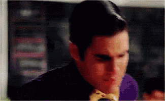 a man in a purple shirt is eating a hamburger .
