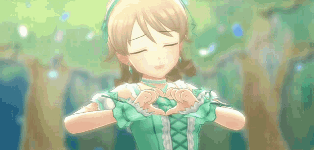a girl in a green dress making a heart shape with her hands