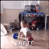 a baby is playing with a ball on the floor and says lift .