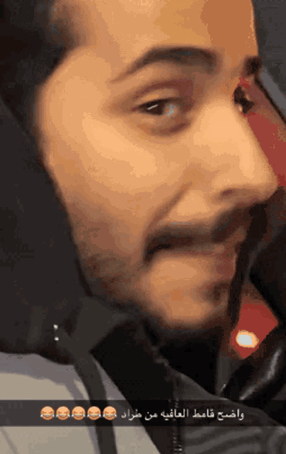 a close up of a man 's face with arabic writing below it