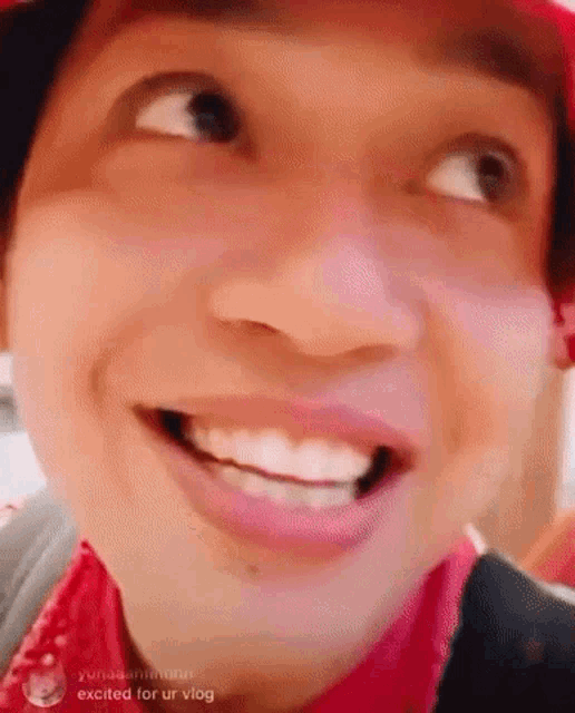 a close up of a man 's face with his mouth open and a red hat .
