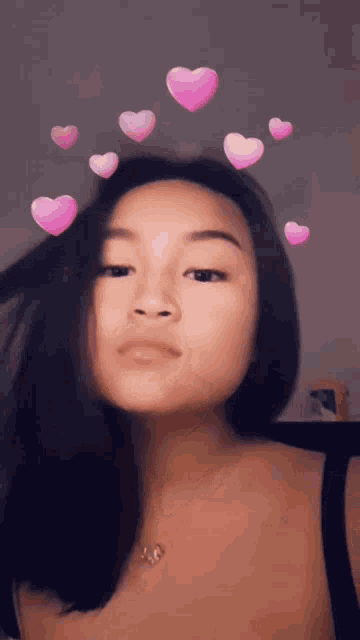 a girl with pink hearts on her head is wearing a black top