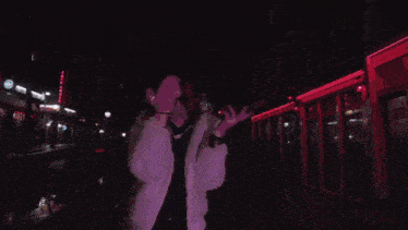 a man and a woman are dancing in front of a castle with the letter t on it