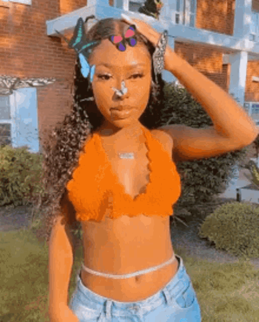 a woman in a crop top with butterflies on her nose .