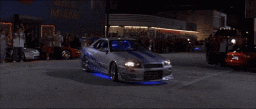 a man is driving a car with a blue light on the dashboard .