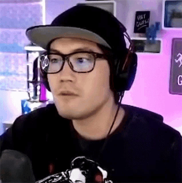 a man wearing glasses and headphones is looking at the camera .