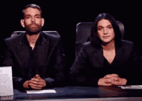 a man and a woman are sitting at a table with a calendar on it
