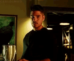 a man in a black shirt is standing in a room with a blender .