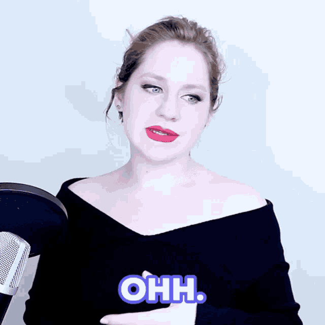 a woman in front of a microphone with the word ohh on her chest