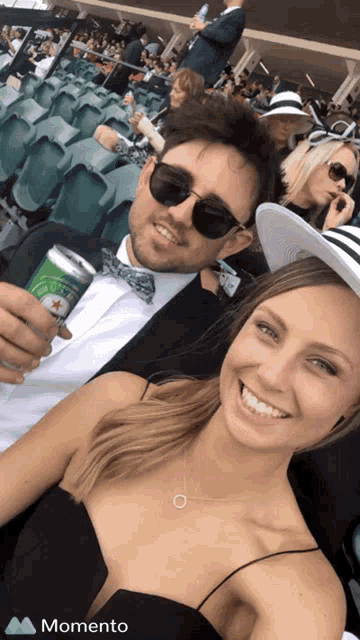 a man holding a can of heineken beer next to a woman