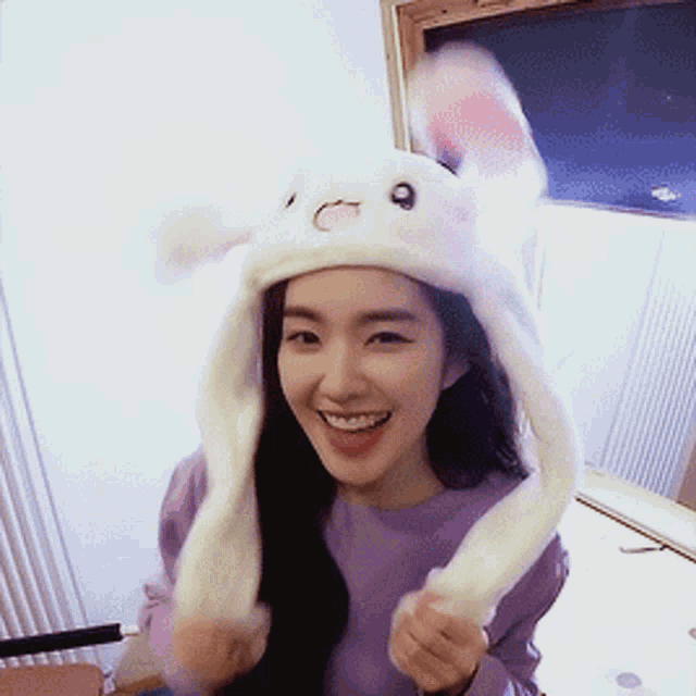 a woman wearing a white hat with bunny ears on it