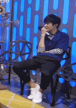 a man sits in a chair with his legs crossed