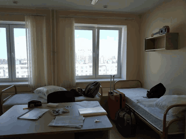 a room with two beds and a table with a clock on it