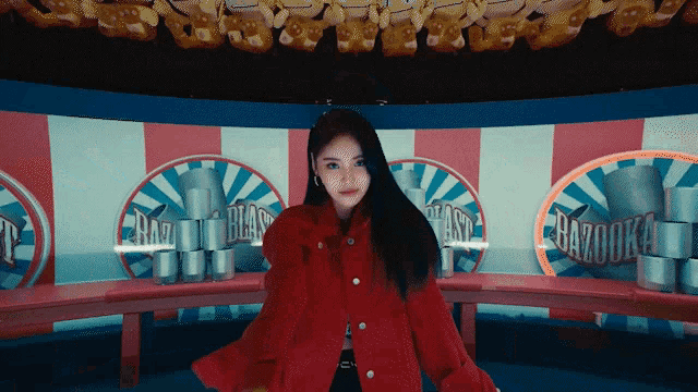 a woman in a red coat is standing in front of a carousel with the words razooka on it