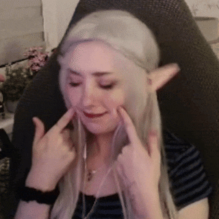 a woman with blonde hair and elf ears is sitting in a chair