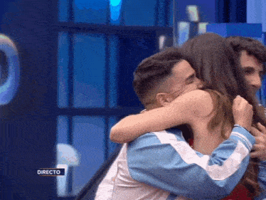 a man and woman hugging in front of a directo sign