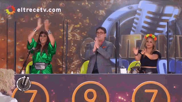a group of people sitting in front of a screen that says eltrecetv.com on it