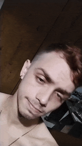 a man without a shirt is taking a picture of himself