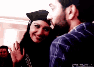 a man and a woman are standing next to each other and the woman is wearing a black hijab