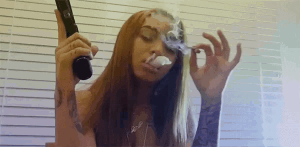 a woman is smoking a cigarette and holding a gun in her hand .