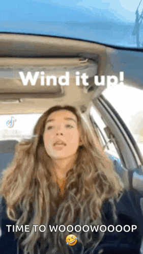 a woman in a car with the words wind it up time to wooowooop