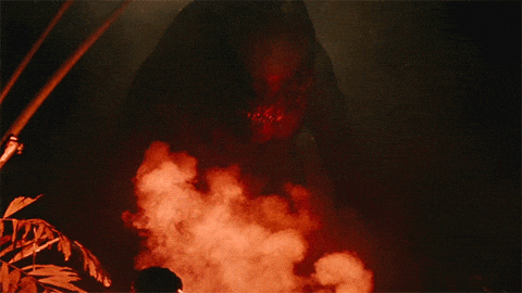 a person standing in front of a large monster with smoke coming out of it