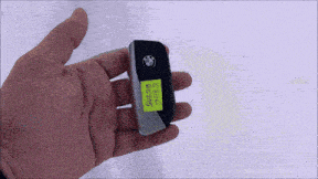 a hand holding a bmw key with a yellow sticker on it that says ' 5358 ' on it