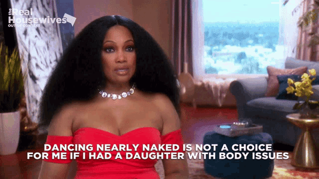 a woman in a red dress is talking about dancing nearly naked