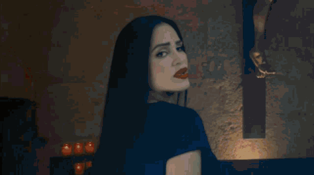 a woman in a futuristic outfit is standing in a dark room