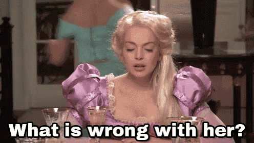 a woman in a purple dress is sitting at a table and asking what is wrong with her ?