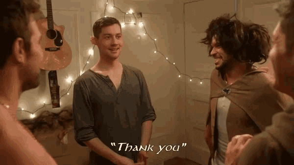 a group of men are standing in a room and one of them is saying thank you