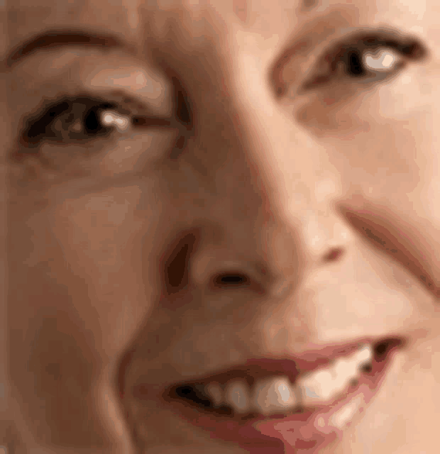 a close up of a woman 's face with a smile .