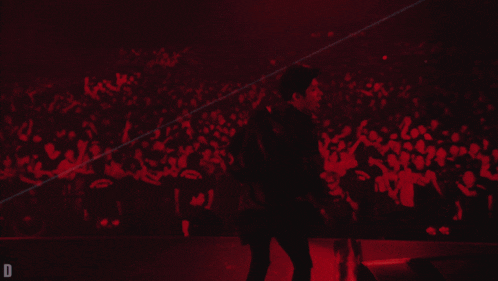 a man is dancing in front of a crowd with the letter d on the bottom