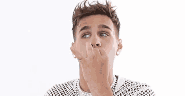 a young man is making a funny face while holding up his hand