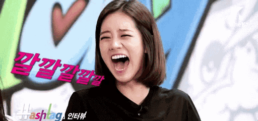 a woman is laughing with her mouth open in front of a graffiti wall .