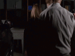 a man and woman are standing in a dark room .