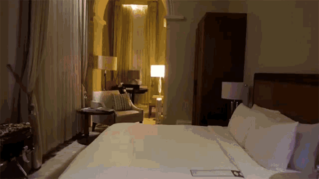 a hotel room with a bed a chair and a table