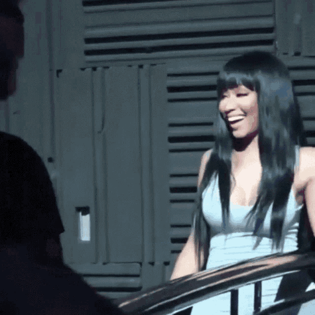 a woman with long black hair is smiling while standing next to a man in a black shirt .