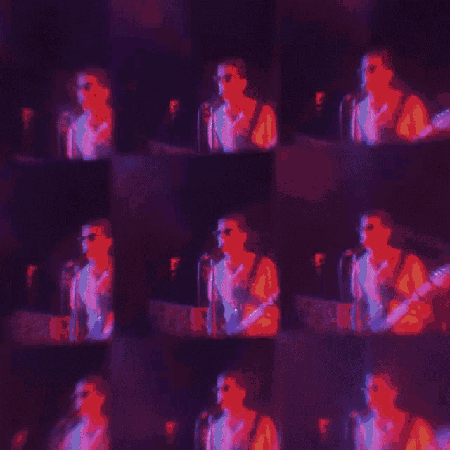 a man is singing into a microphone in a dark room