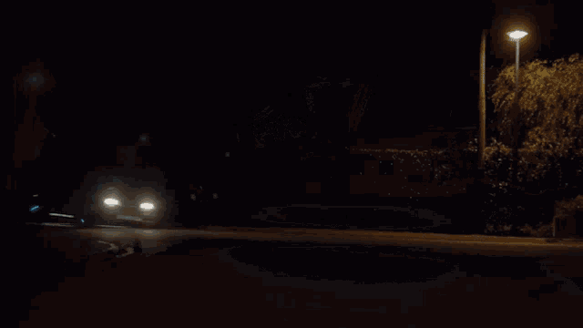 a car is driving down a road at night
