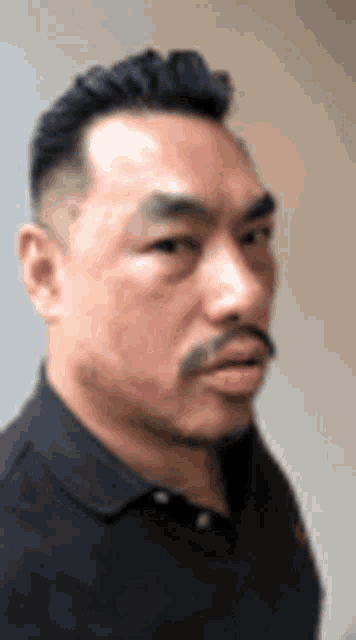 a man with a beard and mustache is wearing a black shirt .