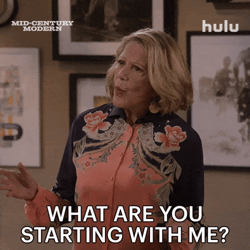 a woman says what are you starting with me in front of a poster for mid century modern
