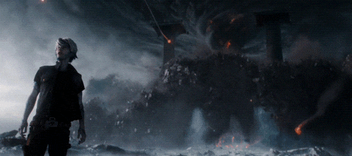 a man in a black shirt is standing in front of a giant monster