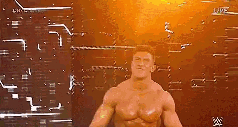 a man without a shirt is standing on a stage in front of a glowing wall .