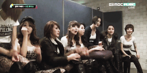a group of women sitting in front of a mbc music live sign