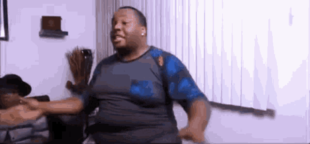 a man is dancing in a living room with his arms outstretched