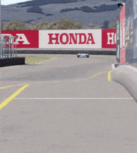 a race car is driving down a track with a honda sign in the background