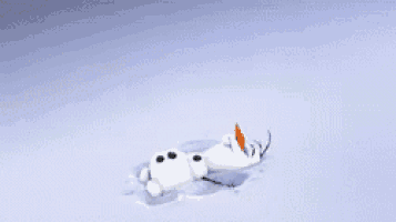 a snowman is laying in the snow with a carrot on his nose .
