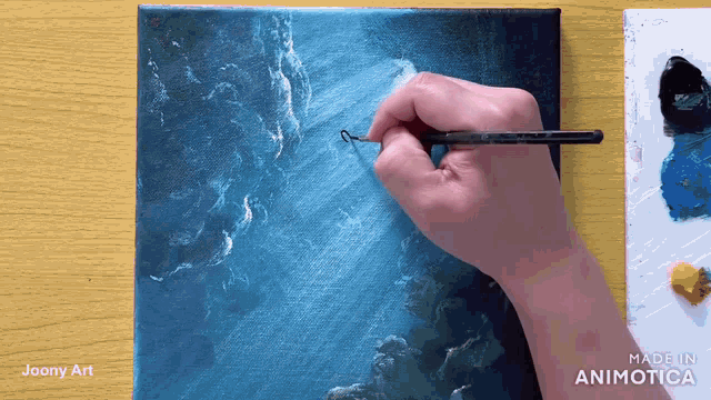 a person is painting on a canvas with the words made in animatica visible