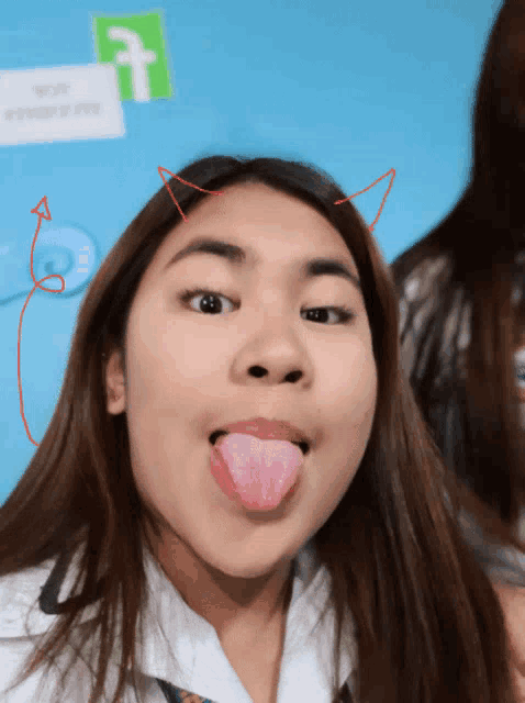 a girl with devil horns on her head sticks out her tongue
